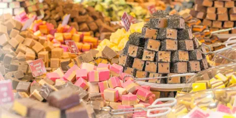 Montón de caramelos de antes, de diferentes sabores y colores, apilados en un puesto.