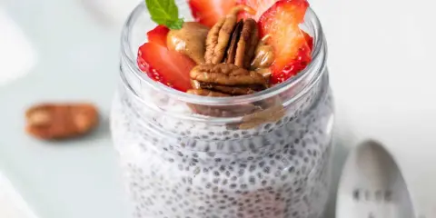 Keto Chia Pudding im Glas mit Erdbeeren, Pekannüssen und Mandelbutter. Ein gesunder Start in den Tag!