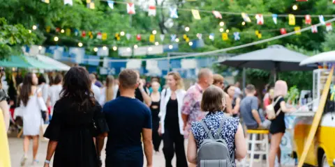 Bunte Flaggen schmücken die Havixbeck Veranstaltungen. Menschen schlendern über einen belebten Markt mit Ständen und Essen.