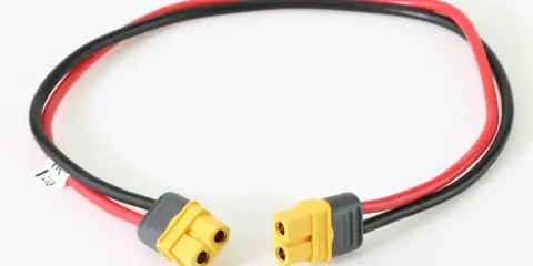 Ein Kabel mit roten und schwarzen Leitungen, das an beiden Enden mit gelben MT60 Steckern versehen ist.