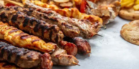 Grillowane szaszłyki z mięsem i warzywami, pyszna turecka potrawa, podane z chlebkiem pita i frytkami.