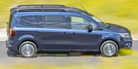 Niebieski, 7-osobowy van z relingami dachowymi pędzi po drodze. To najmniej awaryjny van 7-osobowy, idealny na rodzinne podróże.
