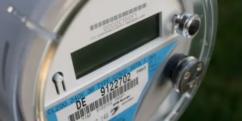 Zbliżenie na licznik energii elektrycznej z etykietą wskazującą na taryfę nocną Energa. Widoczny numer seryjny i dane techniczne.