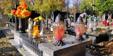Jesienne zaduszki na cmentarzu. Zastanawiasz się, ile kosztuje miejsce na cmentarzu? Kwiaty i znicze na grobach.