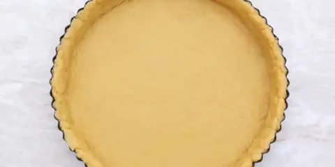 Base di pasta frolla senza glutine pronta per essere farcita.