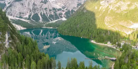 Un lago alpino dai riflessi smeraldo, incorniciato da boschi di conifere e montagne imponenti. Un gioiello tra i quattro laghi del nord Italia.