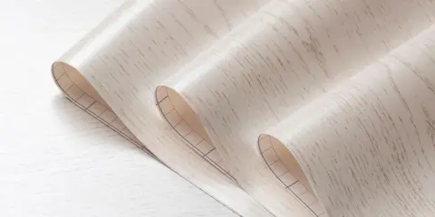 Rolka tapety winylowej imitującej drewno, z siatką na spodzie, idealna do nauki jak usunąć starą tapetę winylową.