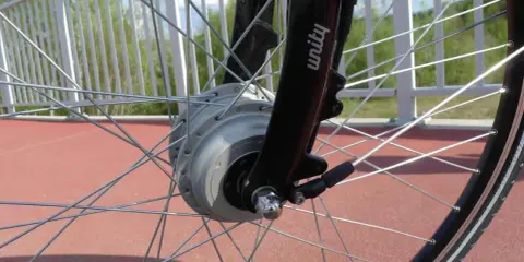 Szprychowe koło roweru elektrycznego z widocznym silnikiem w piaście. Czy na rower elektryczny trzeba mieć prawo jazdy? Sprawdź przepisy!