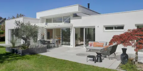 Maison moderne avec extension, terrasse aménagée. L'extension maison architecte obligatoire a créé un espace de vie lumineux et spacieux.