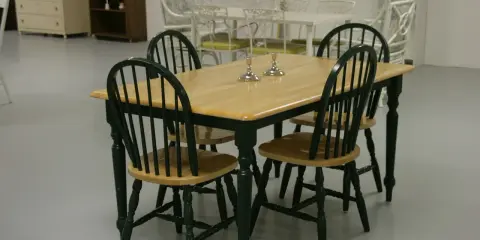 Drewniany stół z zielonymi krzesłami, idealny pomysł na jadalnie. Dwa świeczniki na blacie dodają elegancji.