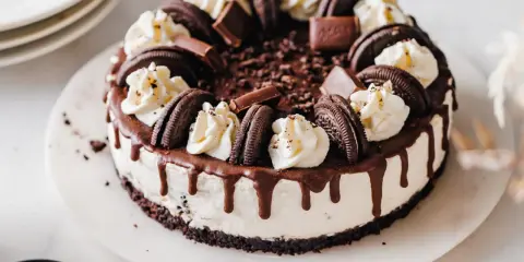 Ein köstlicher Oreo Cheesecake mit Schokoladenglasur und Sahnetupfern. Perfekt für jeden Schokoladenliebhaber.