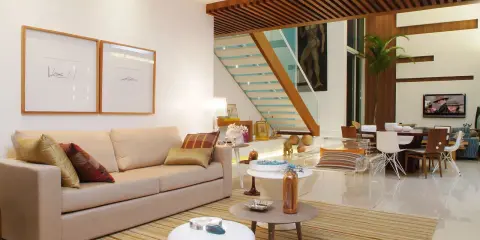 Elegantes salones marrones y beige con sofá, mesas auxiliares, alfombra a rayas y una escalera moderna.
