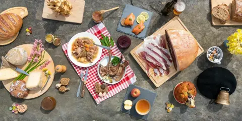 Un festin de spécialités pyrénéennes : charcuterie, fromages, gibier, pain, miel, et douceurs.