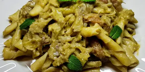 Un piatto invitante di pasta con carciofi, condita con erbe fresche, pronta per essere gustata.