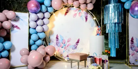 Jak udekorować salę na 18 urodziny? Balony, kwiaty i elegancka ścianka z motywem roślinnym stworzą magiczną atmosferę.