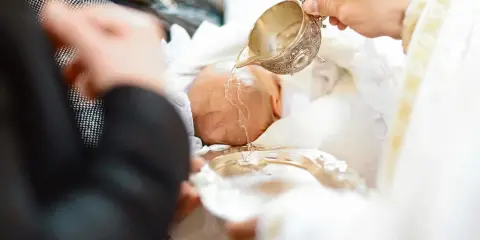 Chrzest dziecka: woda święcona na główkę. Po obrzędzie zakładana jest szatka do chrztu.