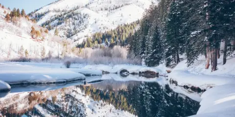 Zimowe góry z dziećmi to idealne miejsce na rodzinne wycieczki. Śnieg, lasy i odbijające się w wodzie góry tworzą magiczny krajobraz.