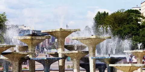 Wielopoziomowa fontanna w Gdyni, z wodą tryskającą na tle miasta. Trasa Gdynia tętni życiem obok tej wodnej atrakcji.