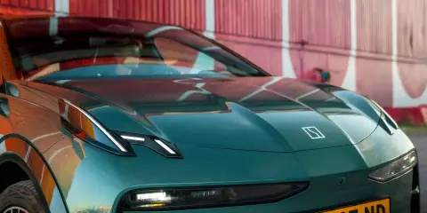 El elegante Zeekr X, un coche eléctrico verde oscuro, se exhibe con su distintivo logo y faros LED, listo para la aventura.