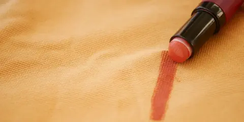 Rossetto su tessuto color pesca, un esempio pratico su come togliere il fondotinta dai vestiti.