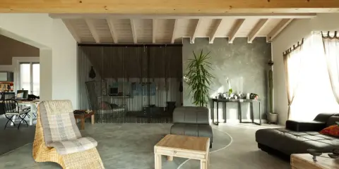 Nowoczesny salon z wygodnymi meblami i gładką, szarą podłogą epoksydową w domu.