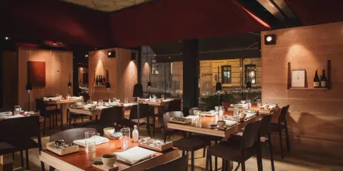 Elegant inredning på en michelin restaurang i Sverige. Vackert dukade bord med trädetaljer och dämpad belysning skapar en intim atmosfär.