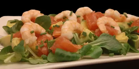 Salade fraîche et colorée : crevettes, avocat, pamplemousse rose, roquette et ciboulette. Un délice léger et savoureux.