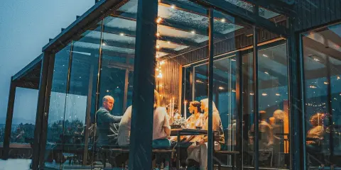 Gemütliches Abendessen im Glasanbau. Die Frage "was kostet ein Wintergarten" stellt sich hier angesichts der Atmosphäre nicht.