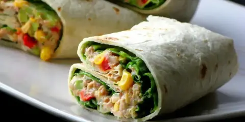 Pyszna tortilla z tuńczykiem, chrupiącą sałatą, kukurydzą i papryką. Idealna na szybki lunch.