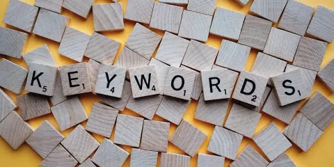 Des tuiles de jeu de mots forment le mot "KEYWORDS". L'orthographe est parfaite pour trouver ce que vous cherchez.