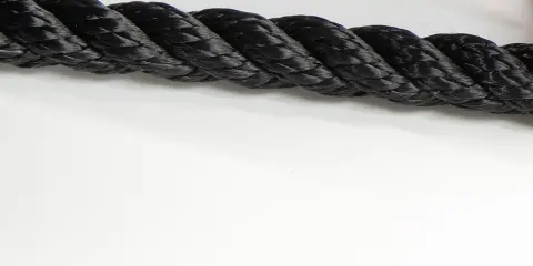 Gros cordage noir tressé, prêt à sécuriser un navire lors de sa prochaine traversée.