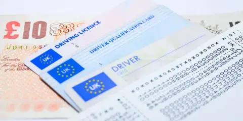 Brytyjskie prawo jazdy, świadectwo kwalifikacji zawodowej kierowcy, karta kierowcy i banknot 10 funtów.