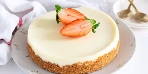 Tarta de cuajada cremosa con base crujiente y fresas frescas. Un postre perfecto para cualquier ocasión.