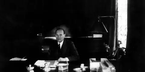 Ivar Kreuger, en svensk ingenjör och industriman, sitter vid sitt skrivbord. En scen som skulle kunna vara från en **Ivar Kreuger film**.