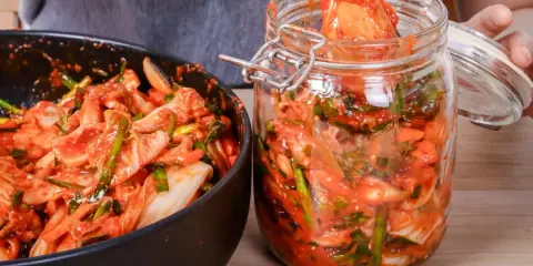 Kimchi w misce i słoiku, gotowe do przechowywania.