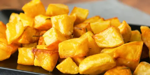 Un piatto invitante di patate al forno croccanti, dorate e saporite, pronte per essere gustate.