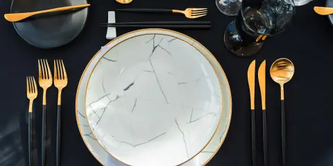 Une table dressée avec élégance, évoquant une ancienne tradition française. Vaisselle moderne aux accents dorés, prête pour un repas raffiné.