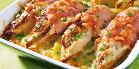 Gebackener Chicorée in Schinken gewickelt, überbacken mit Käse und Kartoffeln. Ein köstliches Gericht für alle, die Rezepte mit Schinken lieben.