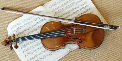 Stradivarius instrument leży na nutach, gotowy do gry.