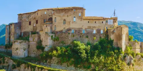 Antico castello su una collina, uno dei borghi medievali vicino Roma, con un grande orologio sulla torre.