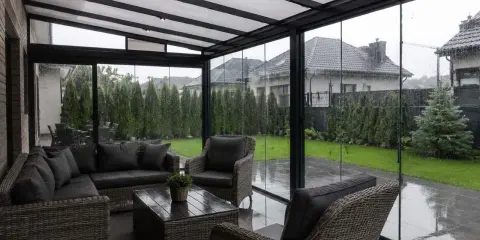 Wygodne meble wypoczynkowe na zadaszonym tarasie, idealne na deszczowy dzień.