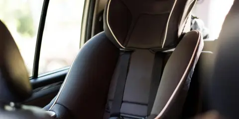 Silla de coche infantil, con cinturón de seguridad y detalles en blanco. La etiqueta indica ece r44/04 vigencia, asegurando su conformidad.