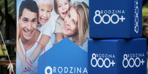 Szczęśliwa rodzina na tle hasła "Rodzina 800+". Wniosek ZUS o świadczenie 800+ to szansa na wsparcie dla wielu rodzin.