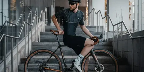 Mężczyzna w stroju kolarskim siedzi na rowerze z ramą 48 cm, idealną dla osób o wzroście ok. 170-175 cm.