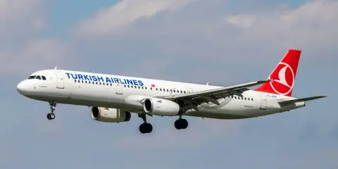 Turkish Airlines flygplan med landningsstället nere, redo för landning. Perfekt för din turkish airlines handbagage-resa.