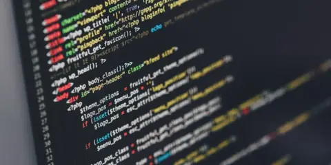 Fragment kodu PHP, który ilustruje zasady programowania. Widać tu zmienne, warunki i funkcje.