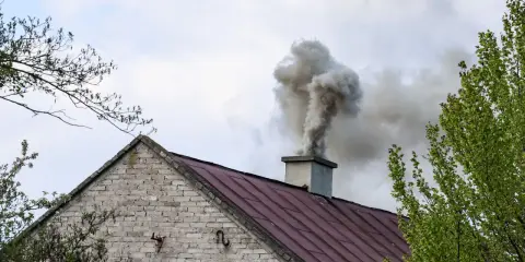 Gęsty dym z komina domu. Kto pobiera opłaty za emisję CO2, gdy takie widoki stają się codziennością?