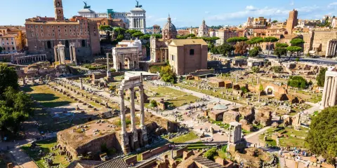 Antike Ruinen des Forum Romanum in Rom, 753 v. Chr. gegründet, mit Säulen, Bögen und Gebäuderesten unter blauem Himmel.