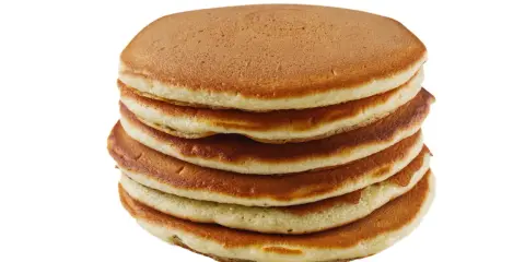 Pile de pancakes dorés faits maison avec de la farine complète, prêts à être dégustés.