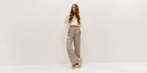 Elegancka kobieta w luźnych spodniach i koszuli. Lyocell: wady i zalety tego materiału w modzie.